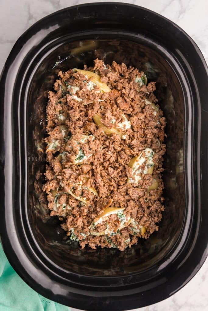 browned sausage in a black crockpot.