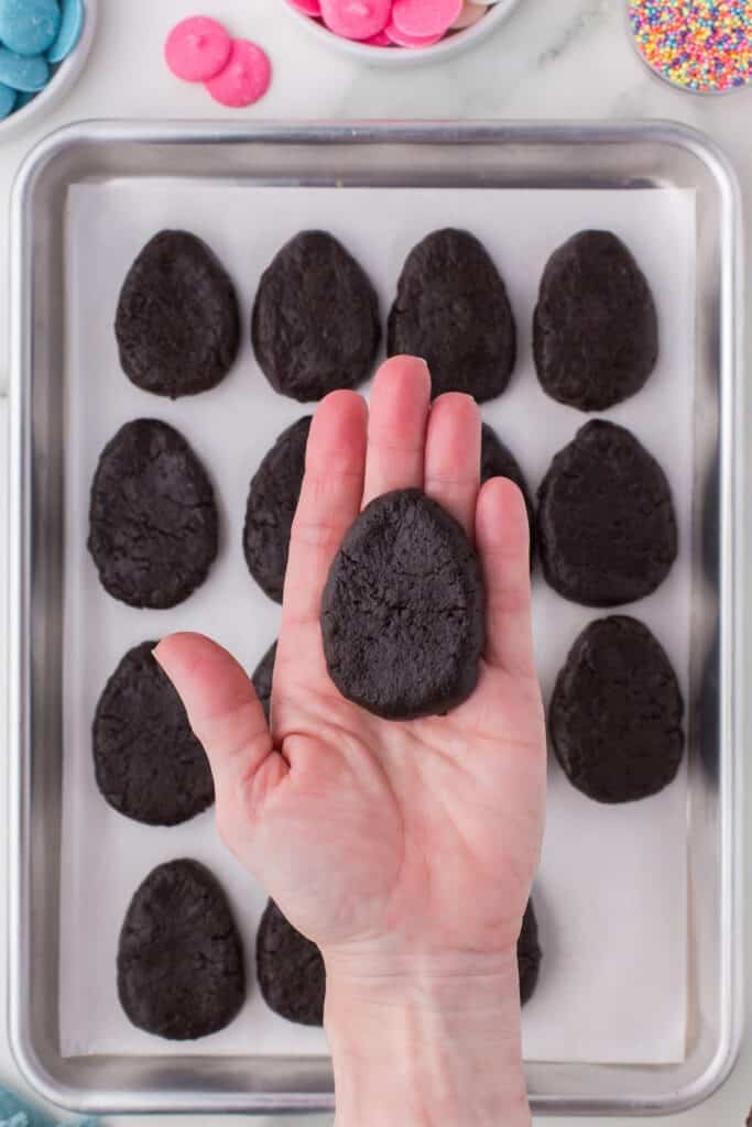 hand holding an oreo truffle shaped like an egg.