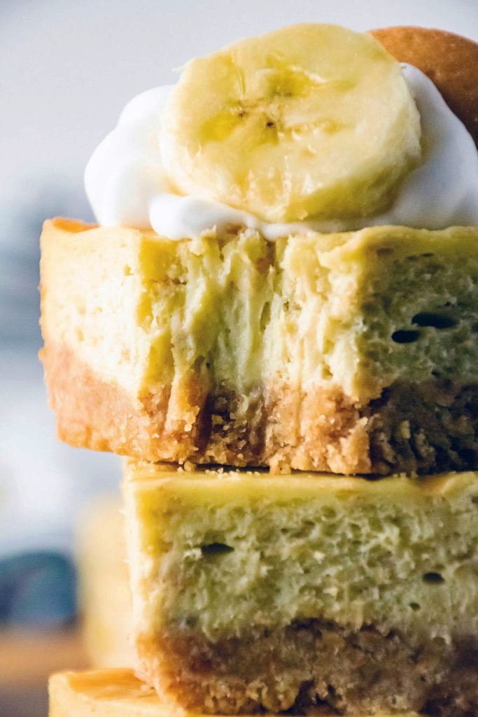 closeup of a bite taken out of a banana pudding cheesecake bar.