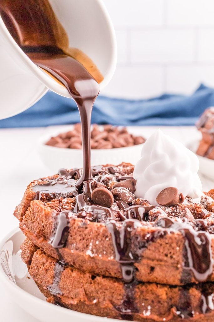 chocolate sauce pouring onto a stack of