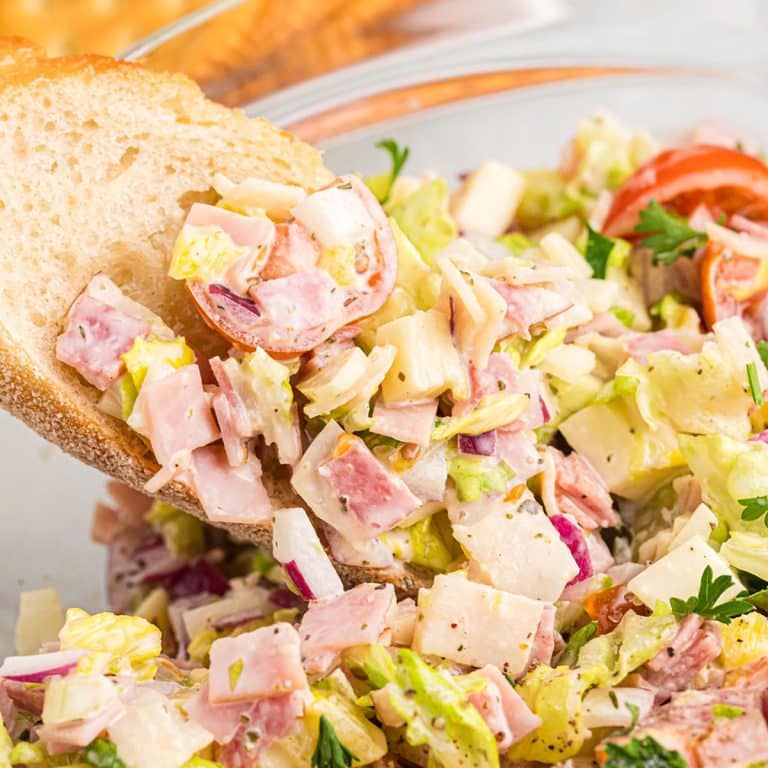 piece of bread dipping into italian hoagie dip.