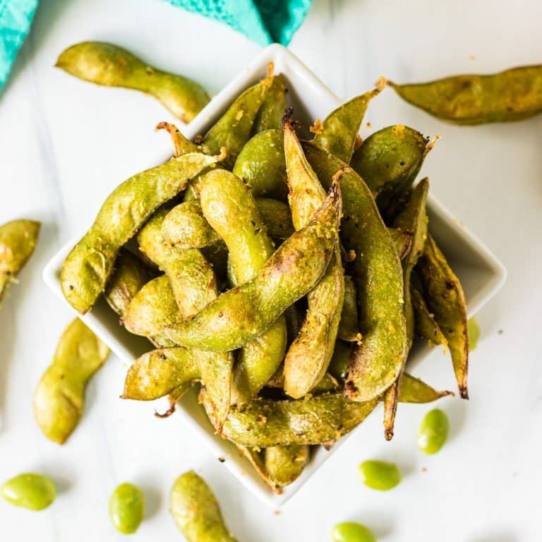 overhead shot of roasted edamame with a teal linen.