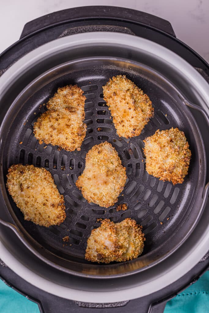 boneless chicken wings in an air fryer basket.