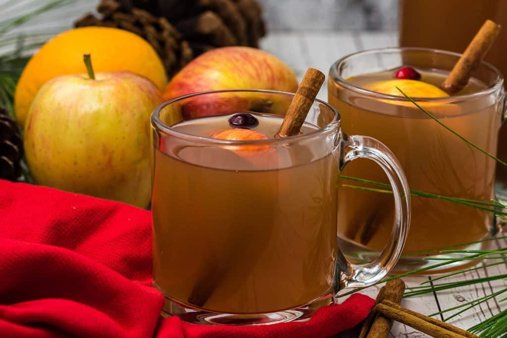 glass mug of hot cider with a red napkin.