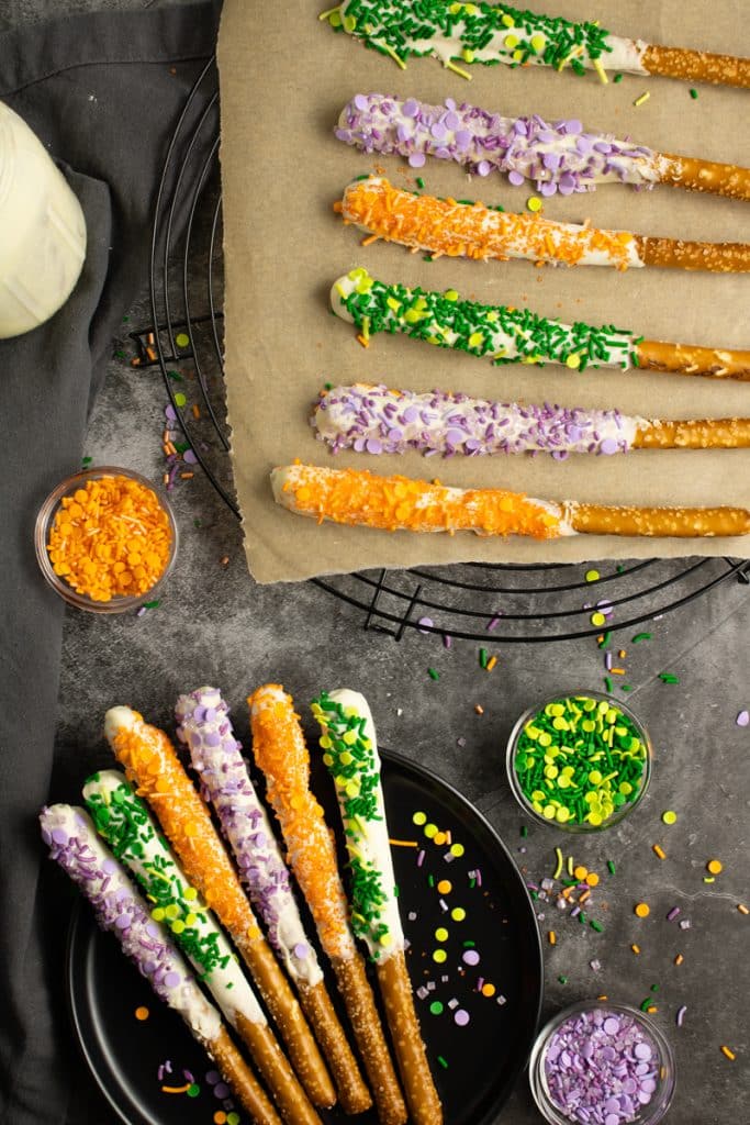 overhead shot of chocolate dipped pretzels with halloween sprinkles.