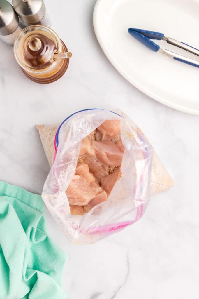 overhead shot of raw chicken pieces in a zip top bag.