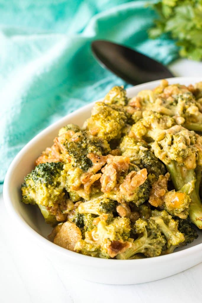 cheesy broccoli casserole in a white serving dish.