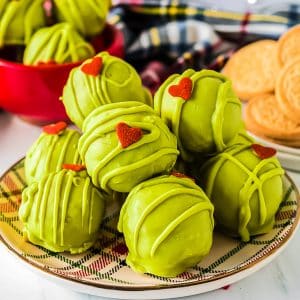 plate of green grinch oreo balls with a heart shaped sprinkle.