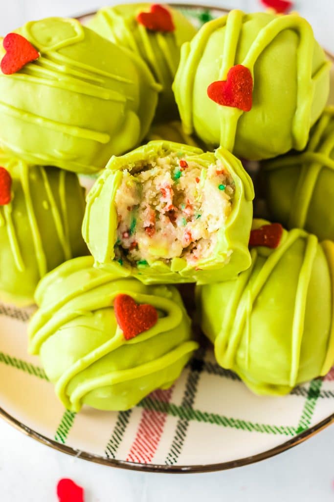 plate of green grinch oreo balls with a bite taken out of one.