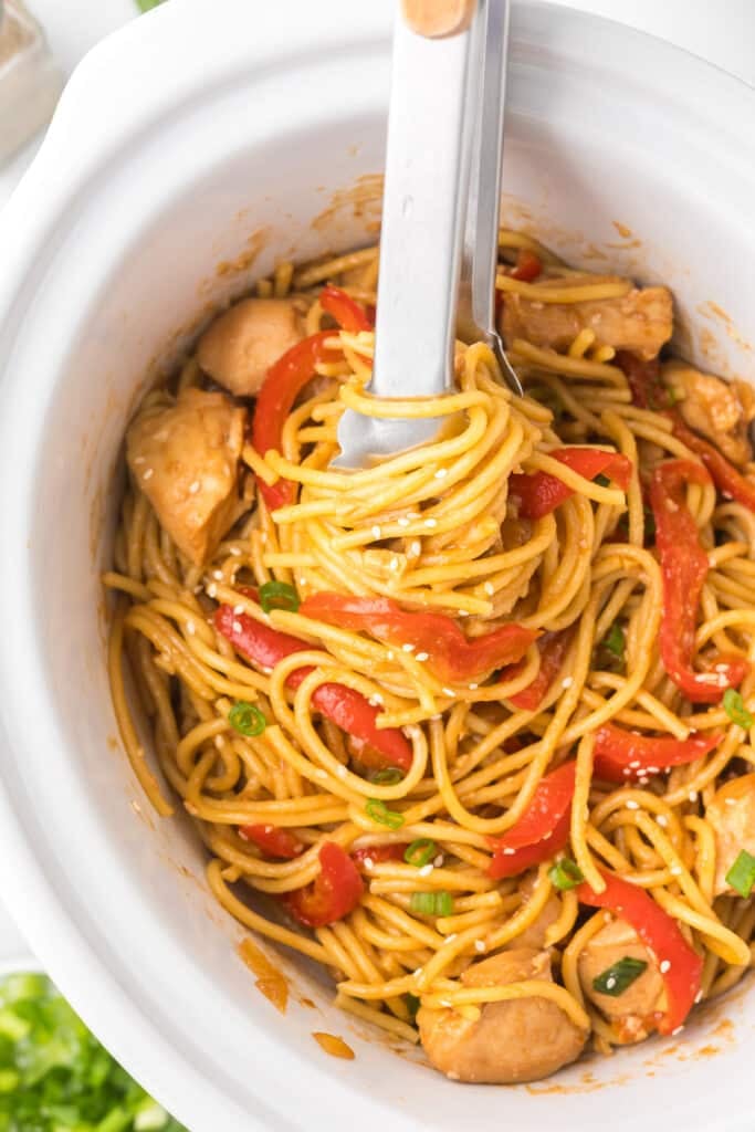 tongs with noodles wrapped around them.