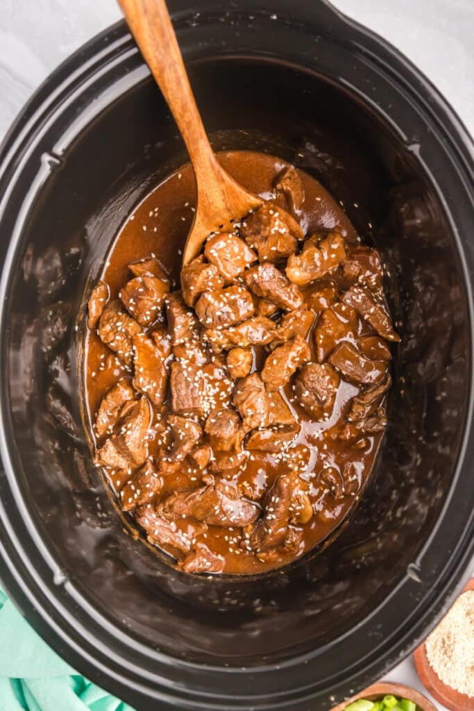 overhead shot of honey garlic steak bites in a slow cooker.
