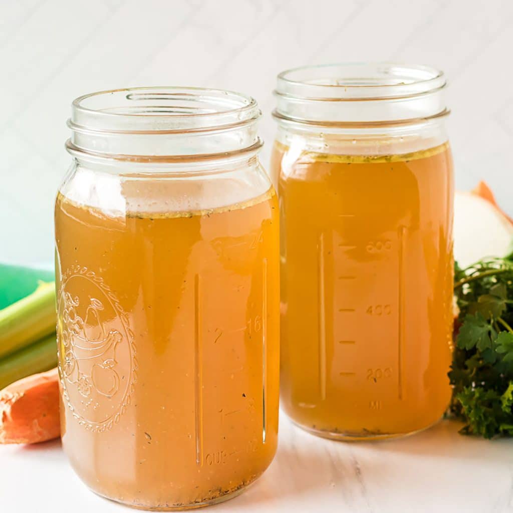 two mason jars filled with homemade chicken stock.
