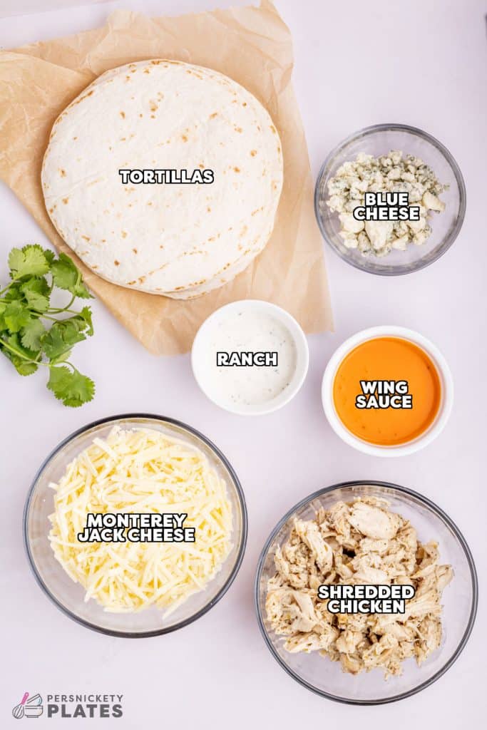 overhead shot of labeled ingredients laid out to make buffalo chicken quesadillas.