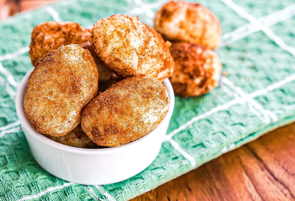white bowl of irish potato candy on a green napkin.