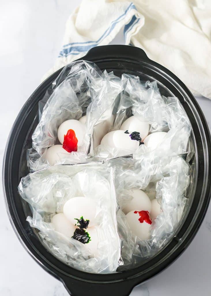 overhead shot of eggs and dye in a slow cooker.