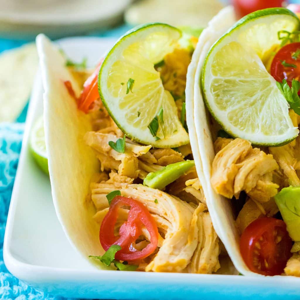 side view of two honey lime chicken tacos on a plate.