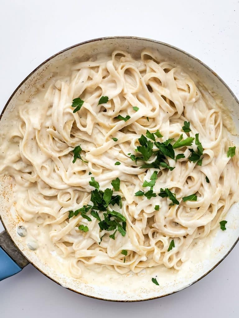 overhead shot of a skillet noodles tossed in homemade alfredo.