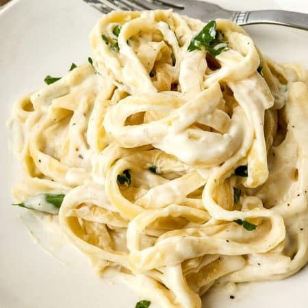 white plate of fettuccine alfredo.