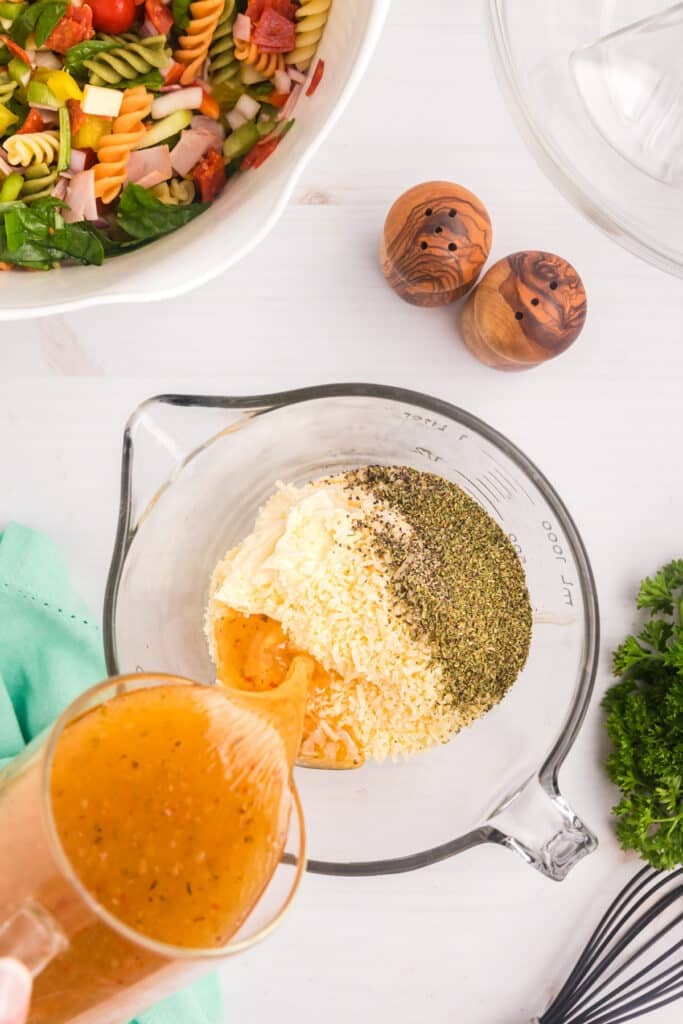 italian dressing pouring into a measuring cup.
