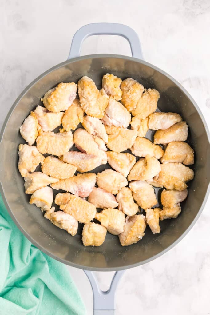chicken pieces in a skillet.