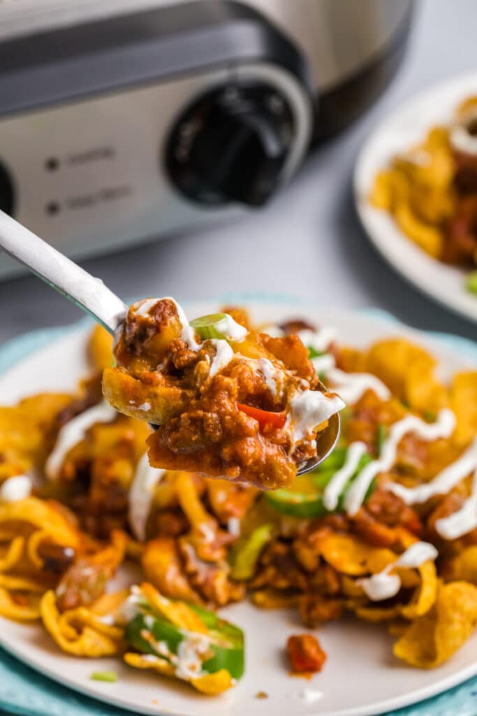 spoonful of frito pie lifting from a plate.