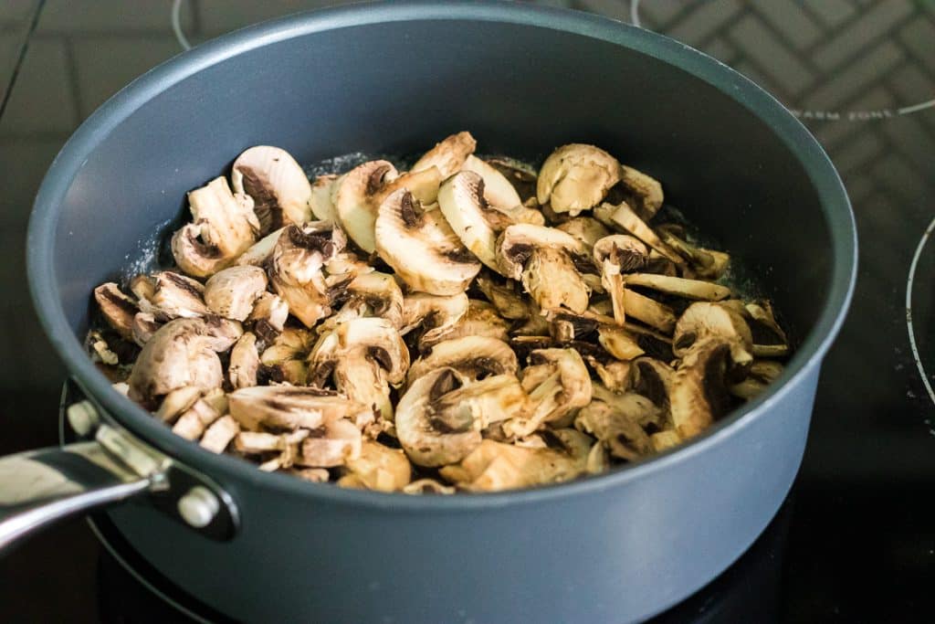 sliced mushrooms in a skillet.