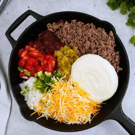 overhead shot of skillet filled with queso ingredients.