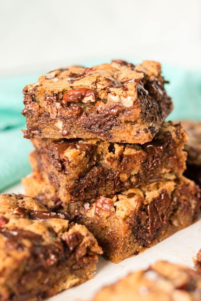 stack of 3 chocolate chip cookie bars with pecans.