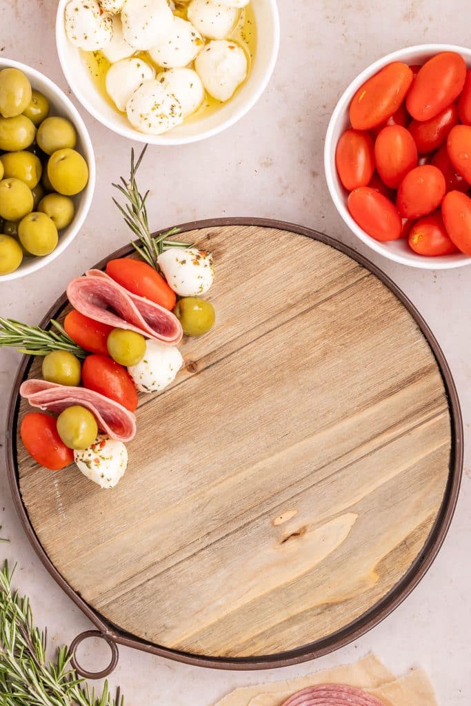 serving platter with meat, cheese, and olives, forming a wreath shapes.