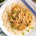 overhead shot of teriyaki chicken on a bed of rice with chopsticks.