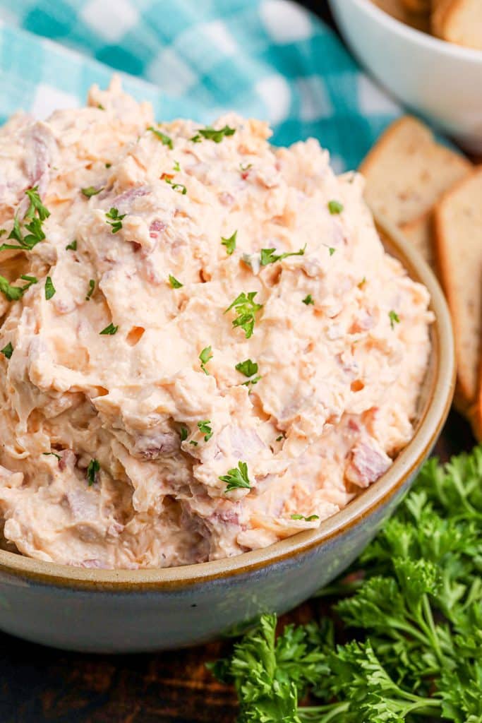 closeup of reuben dip in a bowl next to a blue checked napkin.