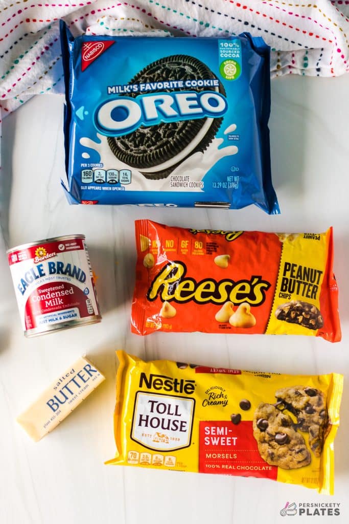 overhead shot of oreos, chocolate chips, peanut butter chips, butter, and sweetened condensed milk.