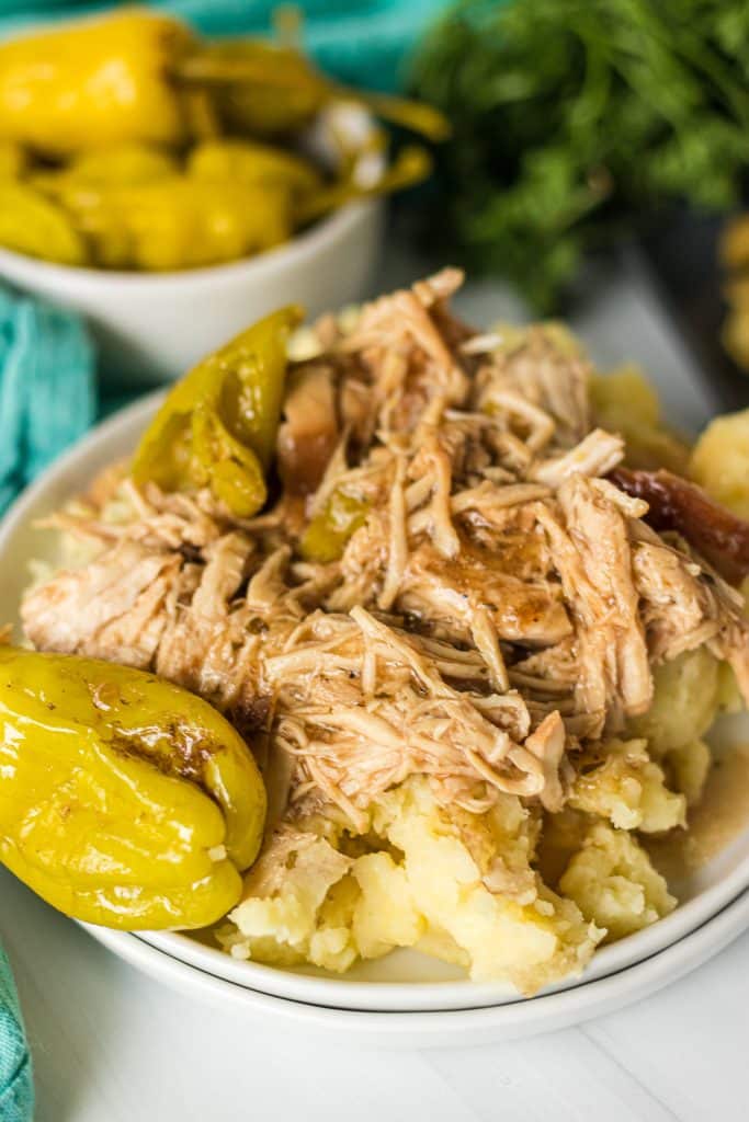 plate of shredded chicken on top of mashed potatoes.