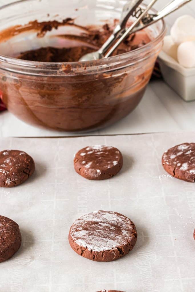 flatten chocolate cookie dough balls on a cookie sheet.