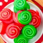 overhead shot of christmas jello roll ups on a white plate.
