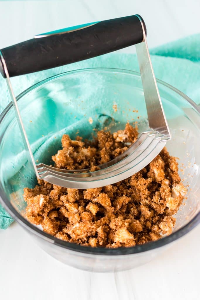 pastry cutter in a bowl of butter and brown sugar.