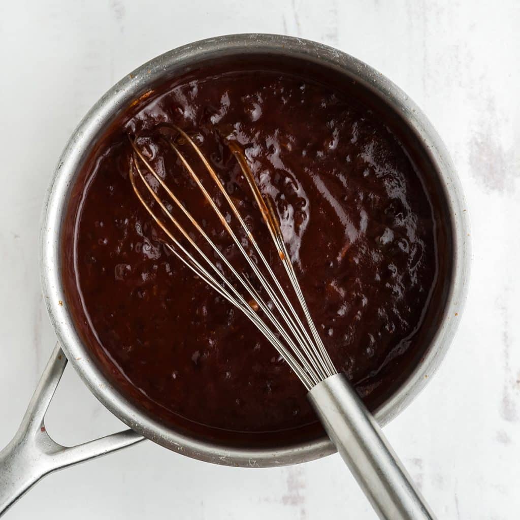 saucepan with sauce and a whisk.