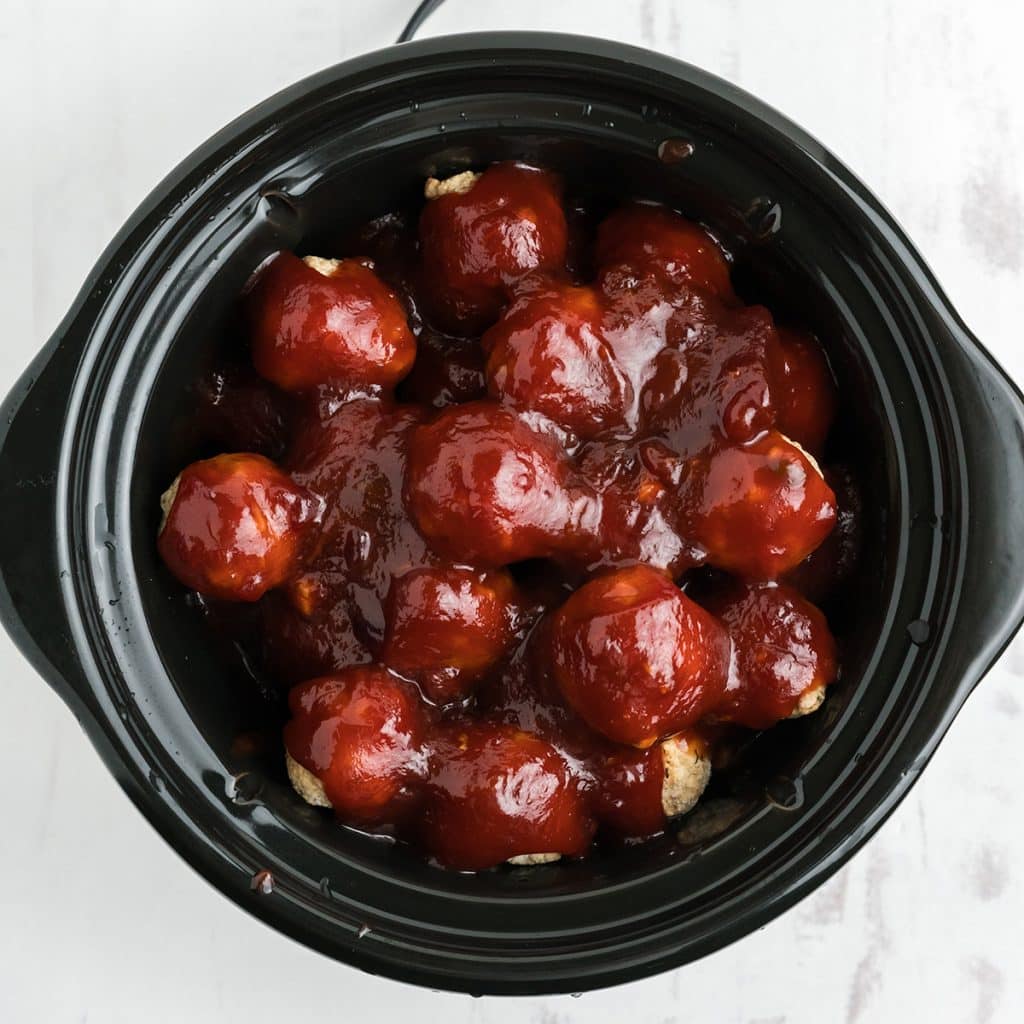 overhead shot of meatballs in a crockpot covered in sauce.