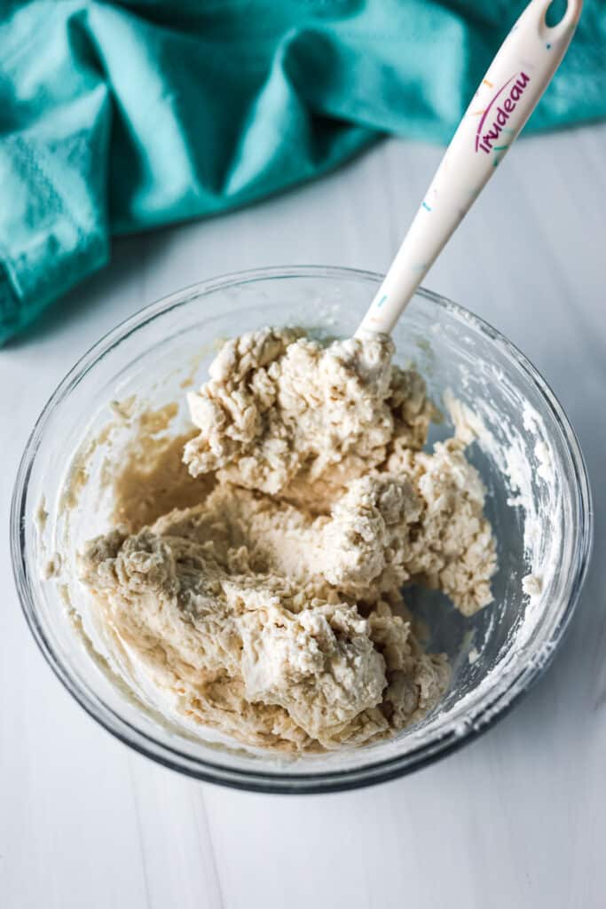 bagel dough in a glass mixing bowl.