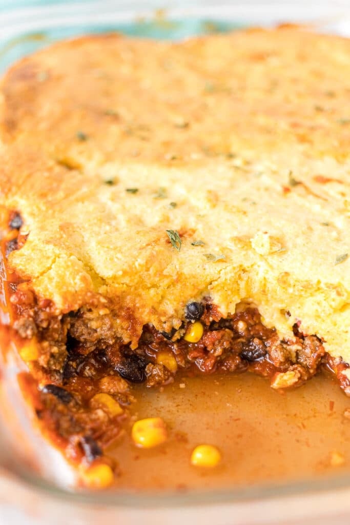 side view of chili cornbread casserole in a baking dish.