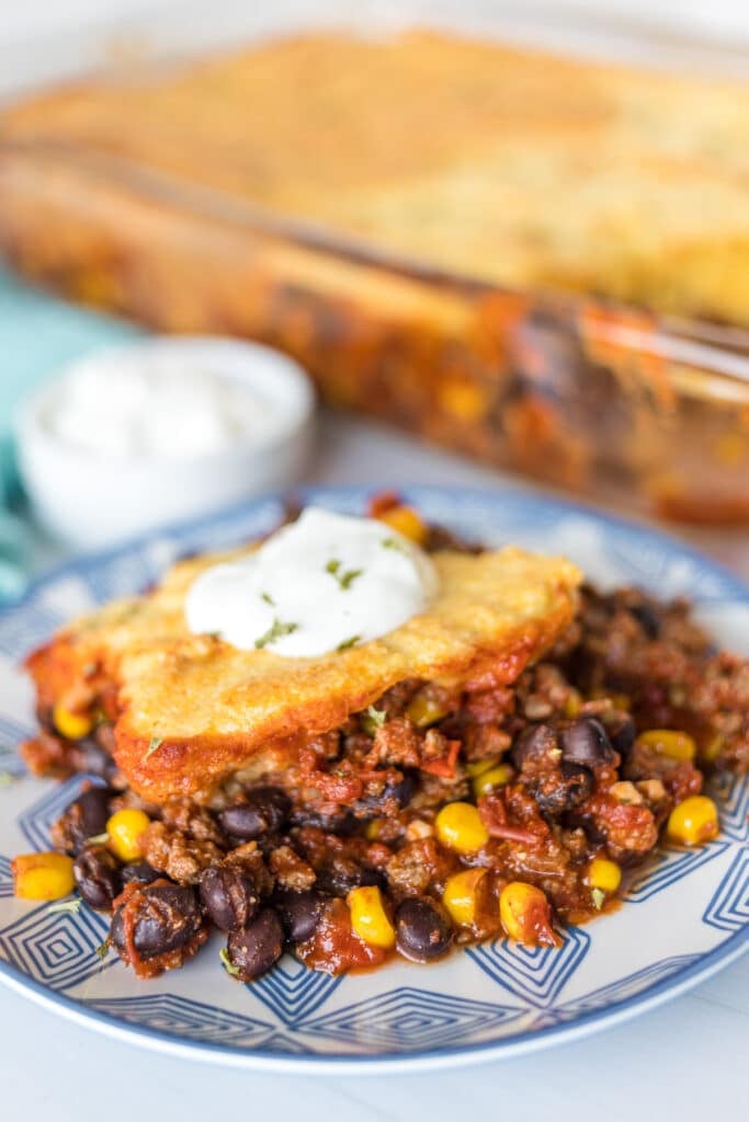 plate of chili cornbread casserole with a dollop of sour cream.