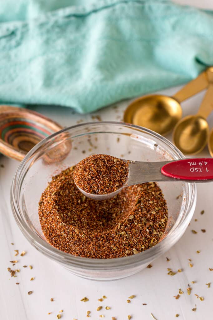 teaspoon lifting chili seasoning from a bowl.