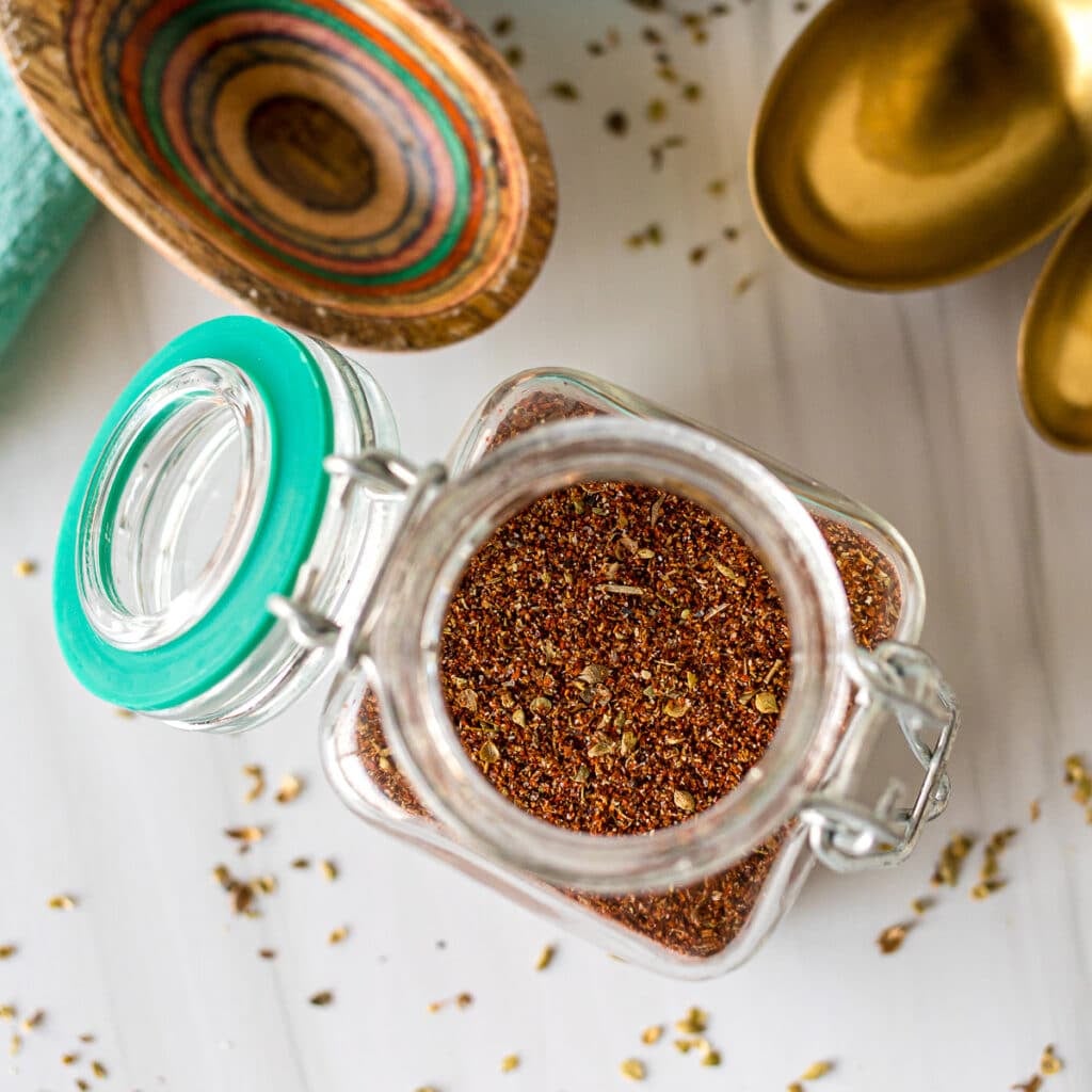 overhead shot of chili seasoning in a glass jar.