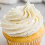 closeup of vanilla buttercream piped onto a yellow cupcake.