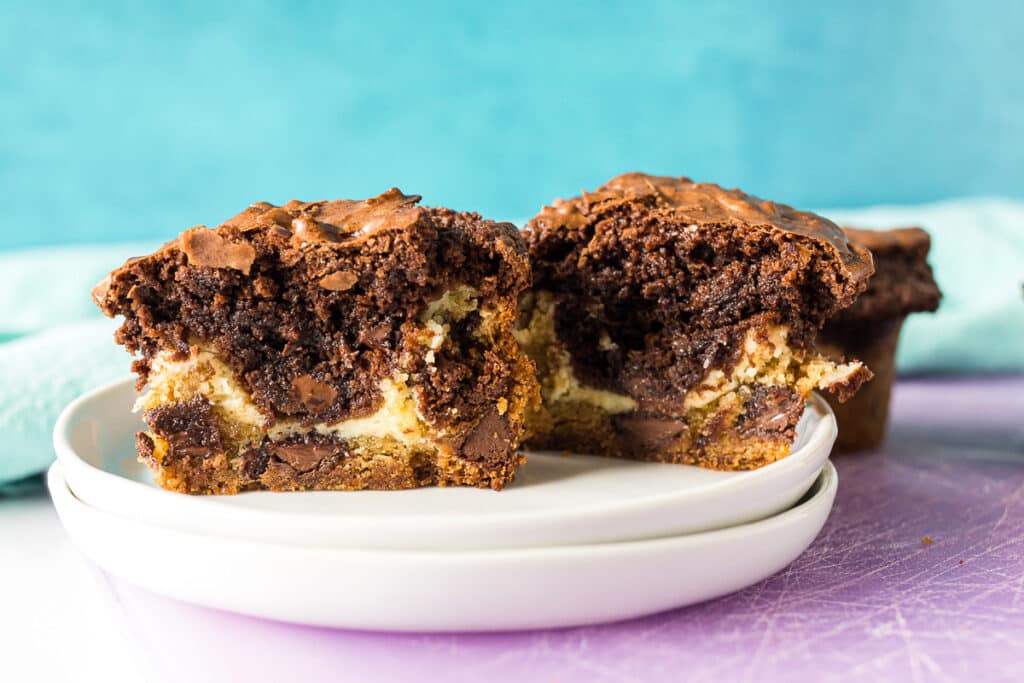 layer of chocolate chip cookie, cheesecake, and brownie in a cookie cup.