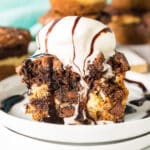 a brookie cheesecake cup topped with vanilla ice cream and hot fudge dripping down.