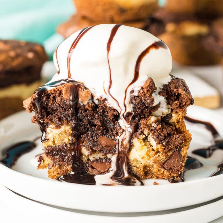 a brookie cheesecake cup topped with vanilla ice cream and hot fudge dripping down.