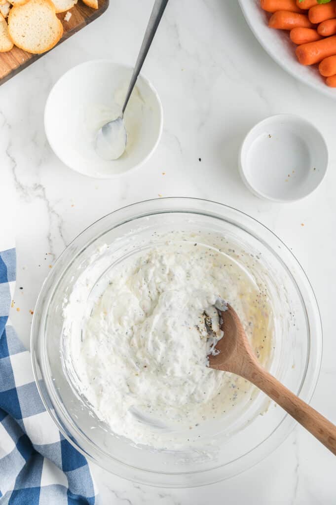 wooden spoon in mixing bowl with cream cheese dip.