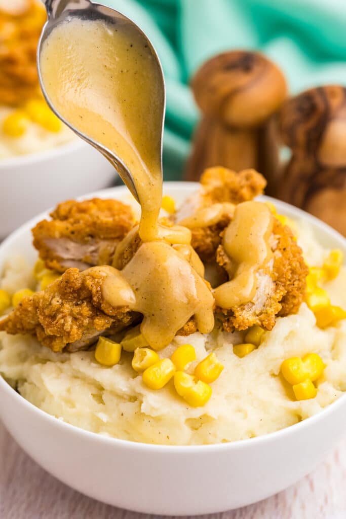 gravy drizzling over a loaded mashed potato bowl.
