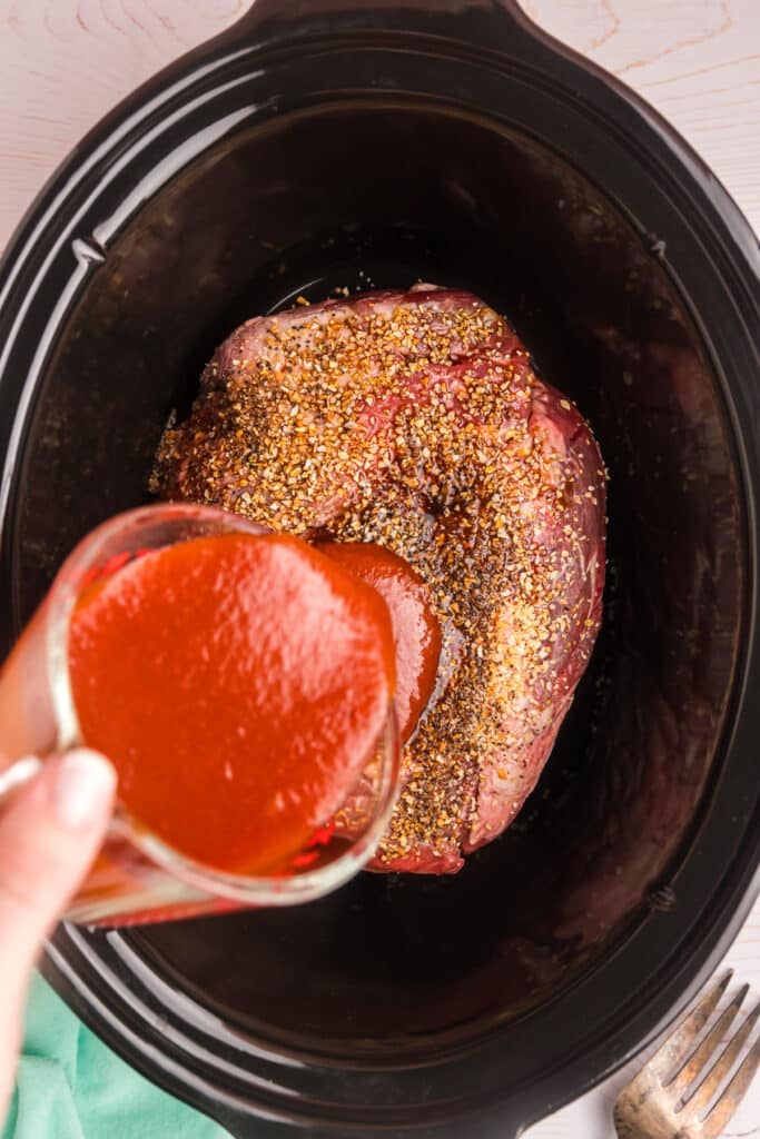 arby's sauce pouring into a crockpot.